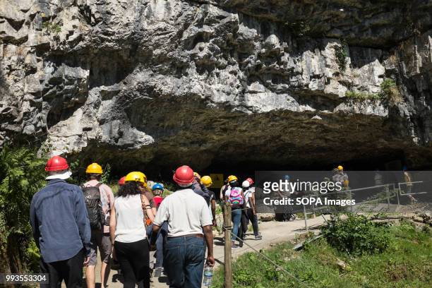 People seen walking into the cave. Ingleborough Cave is a beautiful cave close to the village of Clapham in North Yorkshire, England adjacent to...