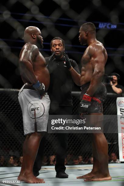 Derrick Lewis and Francis Ngannou of Cameroon take instruction from Herb Dean in their heavyweight fight during the UFC 226 event inside T-Mobile...