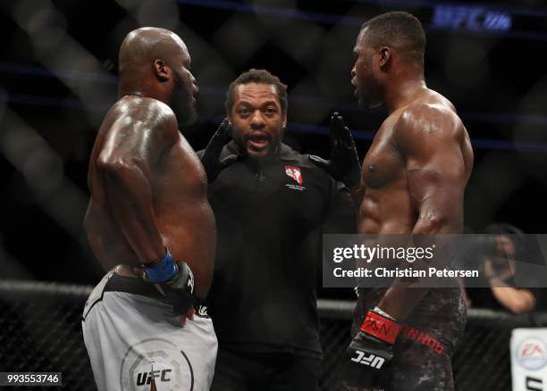 Derrick Lewis and Francis Ngannou of Cameroon take instruction from Herb Dean in their heavyweight fight during the UFC 226 event inside T-Mobile...