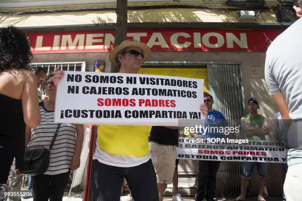 Protester seen holding a poster that says, I'm not a visitor, not an ATM, I'm a father, Joint custody now. Parents demonstrate in front of the PSOE...