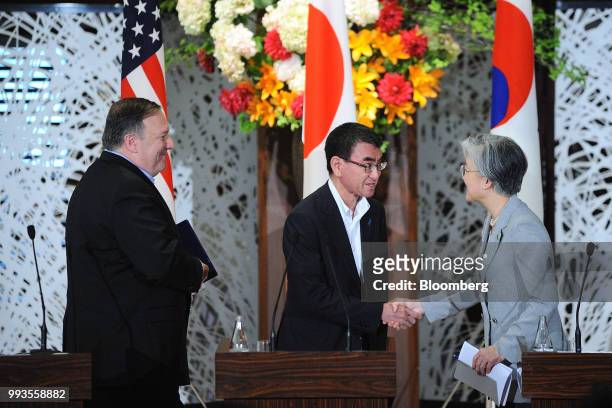 Taro Kono, Japan's foreign minister, center, shakes hands with Kang Kyung-Wha, South Korea's foreign minister, right, as Mike Pompeo, U.S. Secretary...
