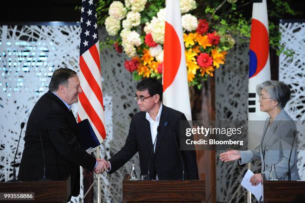 Taro Kono, Japan's foreign minister, center, shakes hands with Mike Pompeo, U.S. Secretary of state, left, as Kang Kyung-Wha, South Korea's foreign...