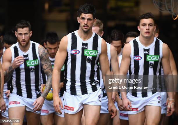 Scott Pendlebury of the Magpies leads his team out onto the field during the round 16 AFL match between the Essendon Bombers and the Collingwood...