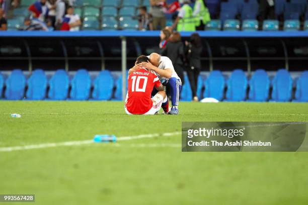Fedor Smolov of Russia is consoled by a team staff after his side's defeat in the 2018 FIFA World Cup Russia Quarter Final match between Russia and...