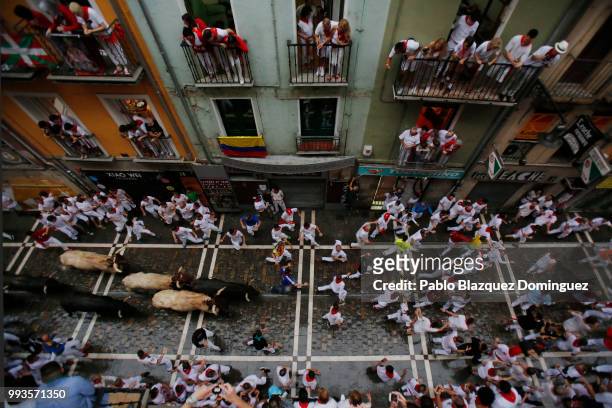 Revellers run with Jose Escolar Gil's fighting bulls during the third day of the San Fermin Running of the Bulls festival on July 8, 2018 in...