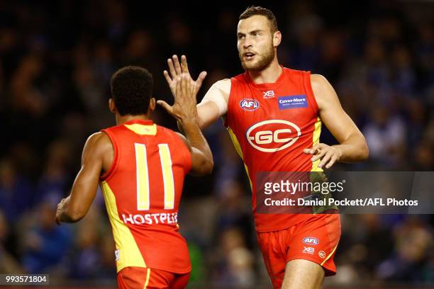 Touk Miller of the Suns celebrates a goal with Jarrod Witts of the Suns during the round 16 AFL match between the North Melbourne Kangaroos and the...