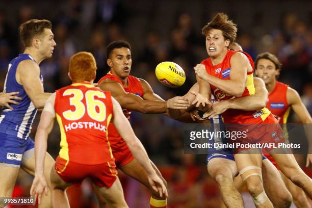 David Swallow of the Suns handpasses under pressure during the round 16 AFL match between the North Melbourne Kangaroos and the Gold Coast Titans at...