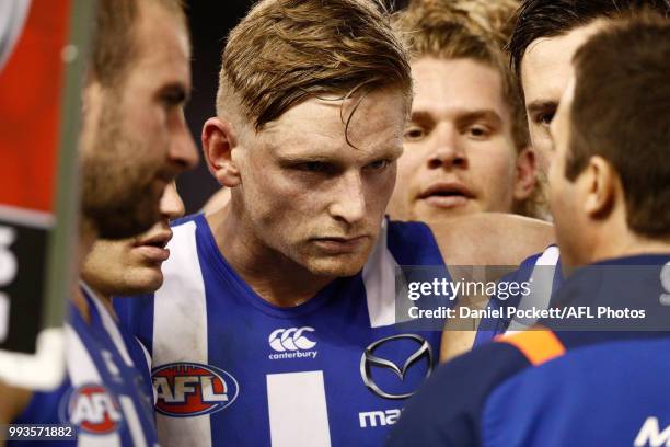 Jack Ziebell of the Kangaroos listens intently to Kangaroos head coach Brad Scott during the round 16 AFL match between the North Melbourne Kangaroos...