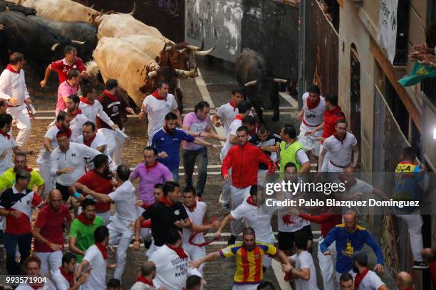 Revellers run with Jose Escolar Gil's fighting bulls during the third day of the San Fermin Running of the Bulls festival on July 8, 2018 in...