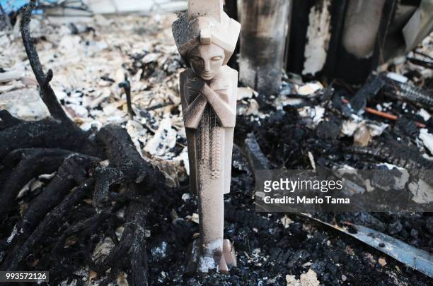 Charred statuette stands in the remains of a destroyed home in the aftermath of the Holiday Fire on July 7, 2018 in Goleta, California. The fire...