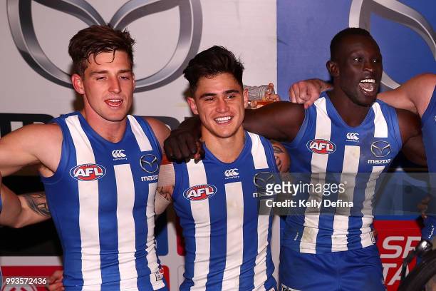 Shaun Atley , Marley Willams and Majak Daw of the Kangaroos sing the song after the Kangaroos victory during the round 16 AFL match between the North...