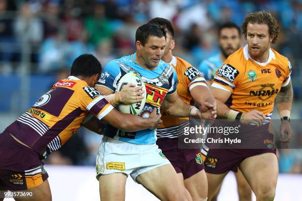 Michael Gordon of the Titans is tackled during the round 17 NRL match between the Gold Coast Titans and the Brisbane Broncos at Cbus Super Stadium on...
