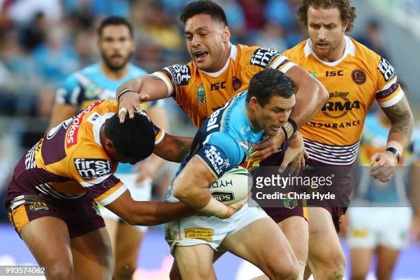 Michael Gordon of the Titans is tackled during the round 17 NRL match between the Gold Coast Titans and the Brisbane Broncos at Cbus Super Stadium on...