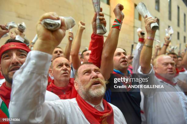 Participants sing before running next to Jose Escolar fighting bulls on the second day of the San Fermin bull run festival in Pamplona, northern...