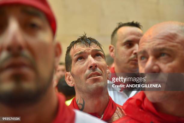 Participants wait before running next to Jose Escolar fighting bulls on the second day of the San Fermin bull run festival in Pamplona, northern...