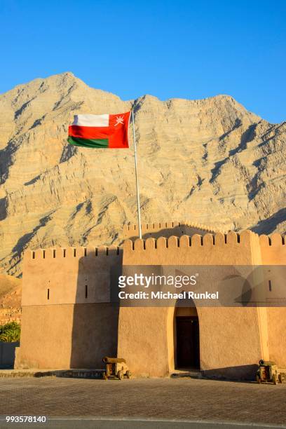 flag of oman, bukha castle, bukha, musandam, oman - arabian peninsula stock pictures, royalty-free photos & images