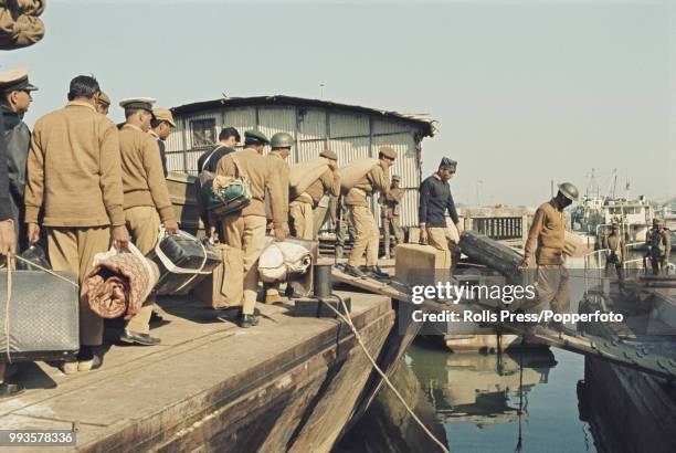 Supervised by armed Indian troops, defeated Pakistan Army soldiers board a boat in Dhaka , East Pakistan for the first stage of their repatriation...