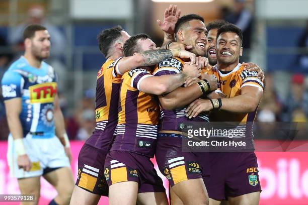 Joe Ofahengaue of the Brocos celebrates with team mates after scoring a try during the round 17 NRL match between the Gold Coast Titans and the...