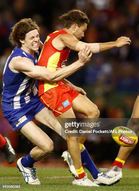 Ben Brown of the Kangaroos tackles Jarrod Harbrow of the Suns during the round 16 AFL match between the North Melbourne Kangaroos and the Gold Coast...