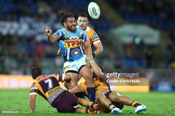 Konrad Hurrell of the Titans passes while tackled during the round 17 NRL match between the Gold Coast Titans and the Brisbane Broncos at Cbus Super...