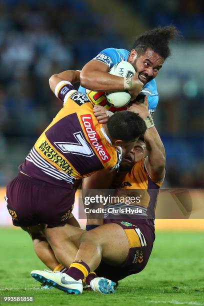 Konrad Hurrell of the Titans is tackled during the round 17 NRL match between the Gold Coast Titans and the Brisbane Broncos at Cbus Super Stadium on...