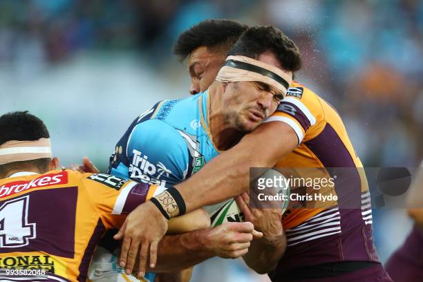 Mitch Rein of the Titans is tackled during the round 17 NRL match between the Gold Coast Titans and the Brisbane Broncos at Cbus Super Stadium on...