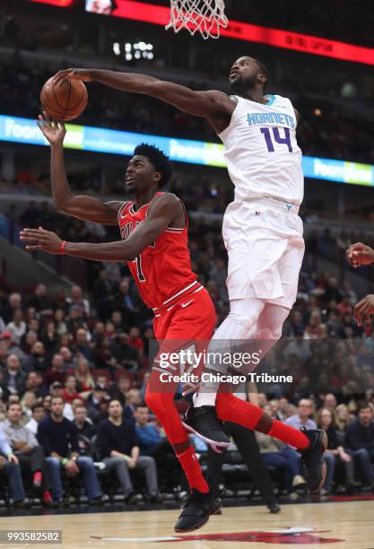 The Chicago Bulls' Justin Holiday is fouled by the Charlotte Hornets' Michael Kidd-Gilchrist at the United Center in Chicago on November 17, 2017.