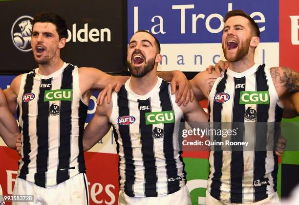 Scott Pendlebury, Steele Sidebottom and Jeremy Howe of the Magpies sing the song in the rooms after winning the round 16 AFL match between the...