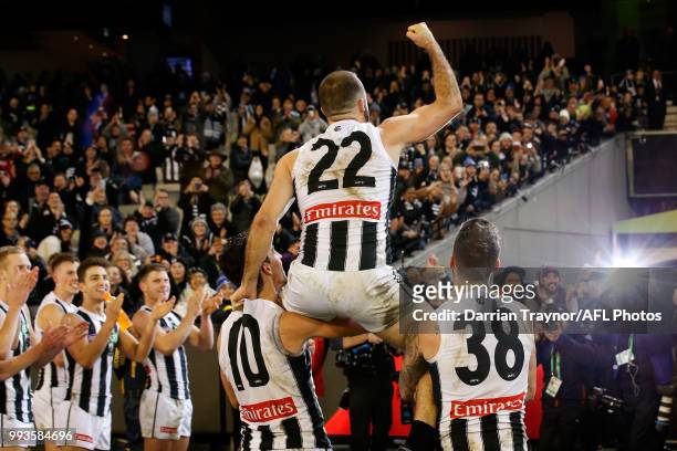 Steele Sidebottom of the Magpies is chaired off by team mates after playing his 200th game during the round 16 AFL match between the Essendon Bombers...