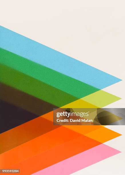 multicoloured paper triangles overlapping on a lightbox. - malan stock-fotos und bilder