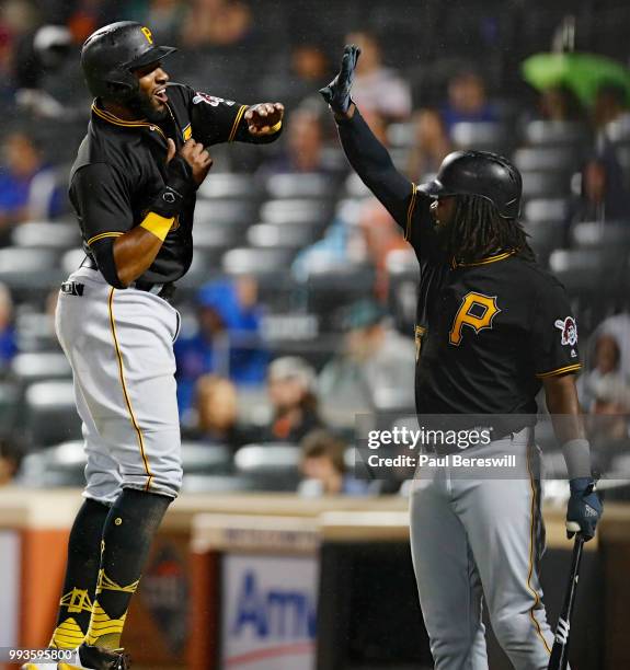 Gregory Polanco of the Pittsburgh Pirates celebrates with teammate Josh Bell after scoring a run in the ninth inning in an MLB baseball game against...