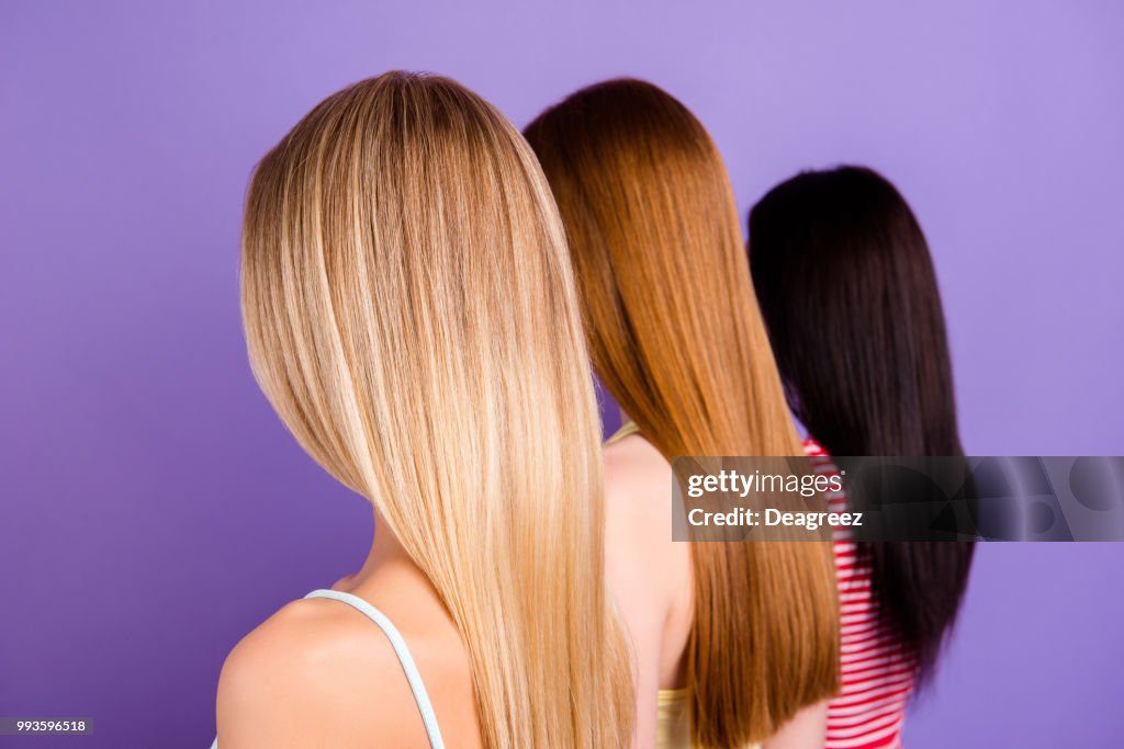 Rear view portrait of trio with different hair color after haircut in beauty salon isolated on vivid violet background. Hair treatment therapy concept