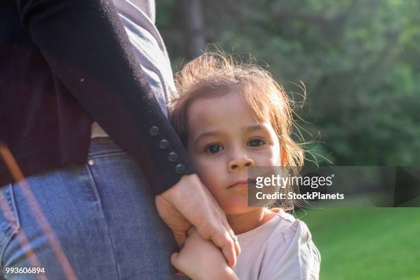 porträtt söt liten flicka står bredvid sin mor - protection bildbanksfoton och bilder