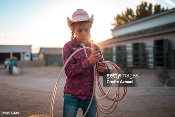 junge cowgirl training auf einer ranch mit dem lasso - cowgirl stock-fotos und bilder
