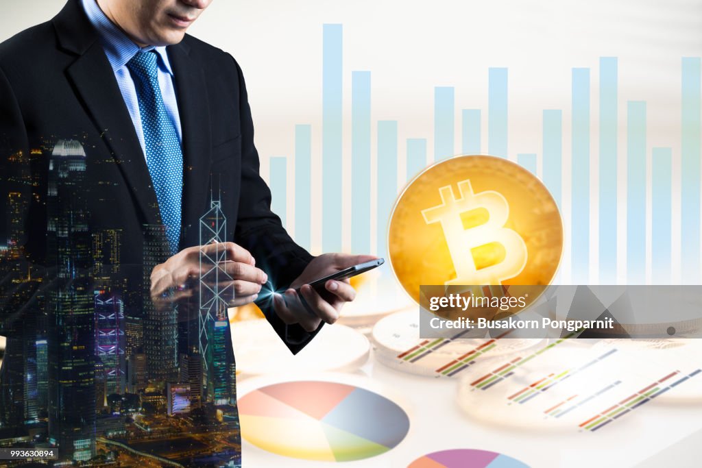Businessman holding smartphone and graph virtual system diagram bitcoin and network background.