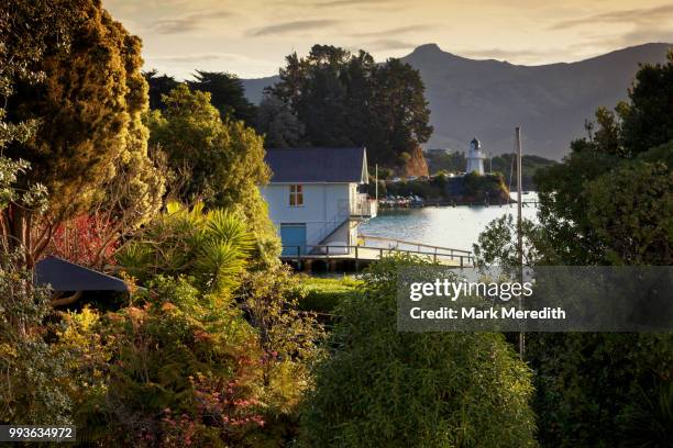 akaroa evening looking over waterfront to historic lighthouse - banks peninsula stock pictures, royalty-free photos & images