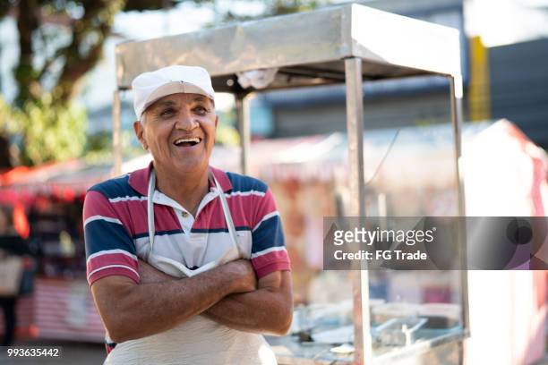 mature man selling churros at street portrait - feirante imagens e fotografias de stock