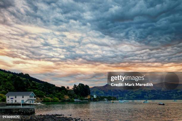 akaroa sunset over the harbour on the banks peninsula - banks peninsula foto e immagini stock