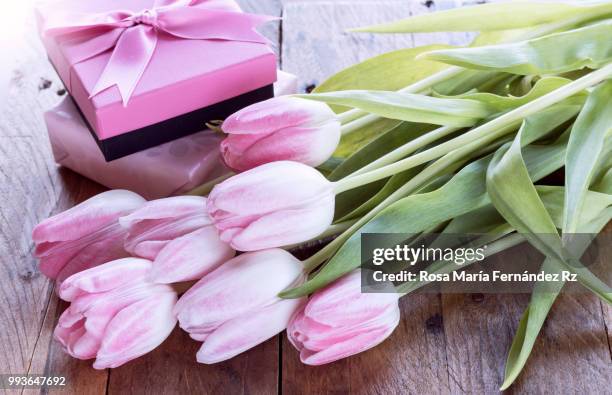 close-up of bouquet of tulips flowers and gift boxes on wooden background. selective focus and copy space. - rz stock pictures, royalty-free photos & images