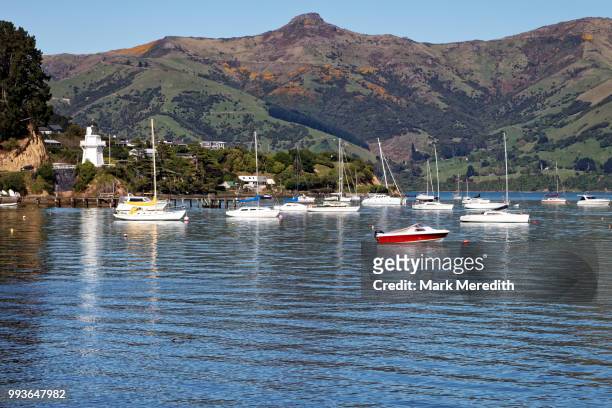 akaroa harbour with moored yachts and boats and mountain range - banks peninsula stock pictures, royalty-free photos & images