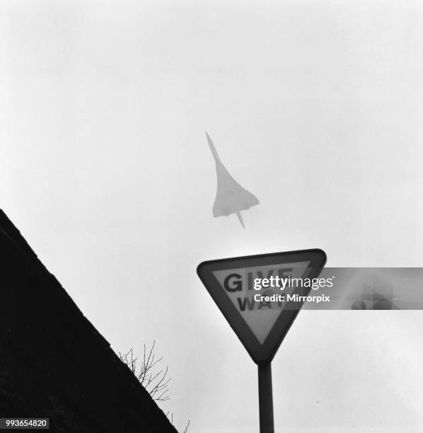 The supersonic airliner Concorde in flight through fog and snow, passing a Give Way sign as it departs from Heathrow Airport en route to the warmer...