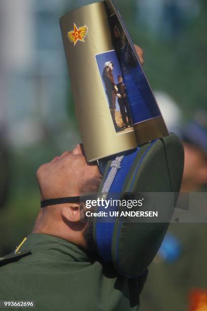 Un soldat chinois regarde le ciel lors d'une démonstration d'une patrouille aérienne de l'amée américaine en septembre 1987 à Pékin, Chine.