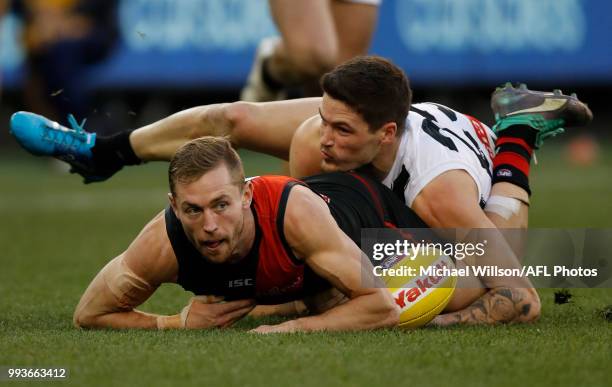 Devon Smith of the Bombers is tackled by Jack Crisp of the Magpies during the 2018 AFL round 16 match between the Essendon Bombers and the...