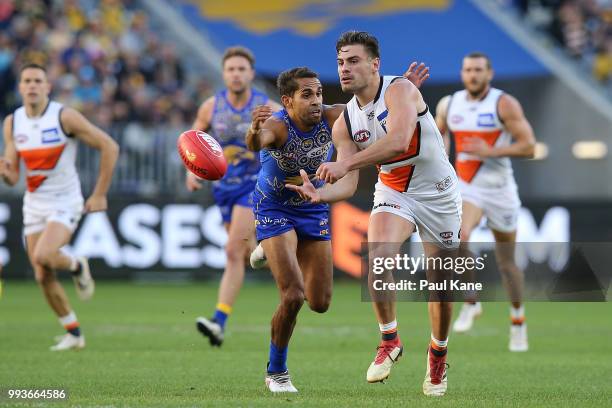 Stephen Coniglio of the Giants gets his handball away under pressure by Lewis Jetta of the Eagles during the round 16 AFL match between the West...