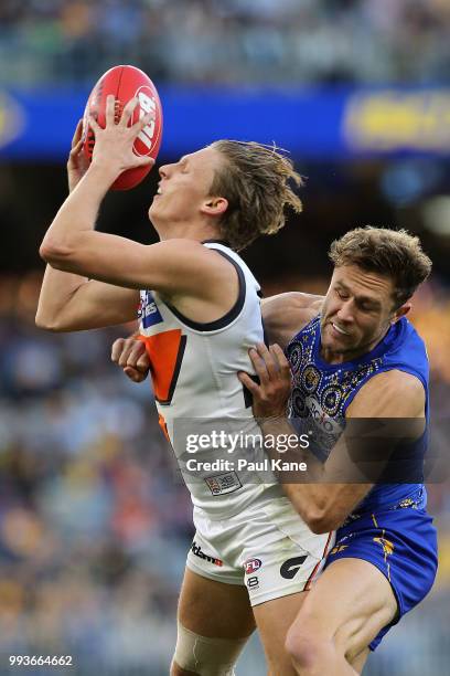 Lachie Whitfield of the Giants marks the ball against Mark Hutchings of the Eagles during the round 16 AFL match between the West Coast Eagles and...