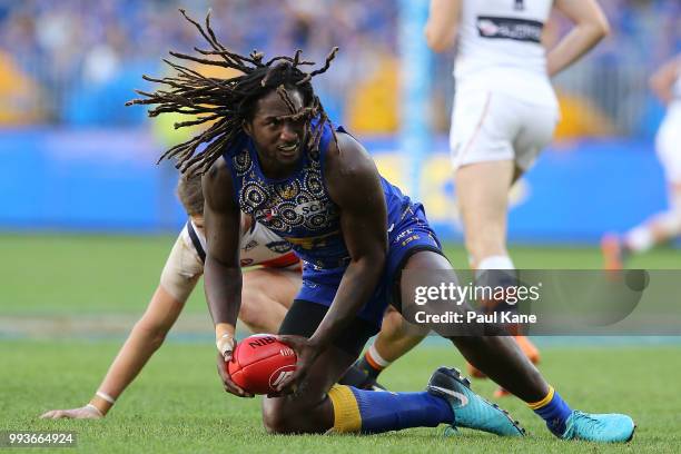 Nic Naitanui of the Eagles looks to handball during the round 16 AFL match between the West Coast Eagles and the Greater Western Sydney Giants at...