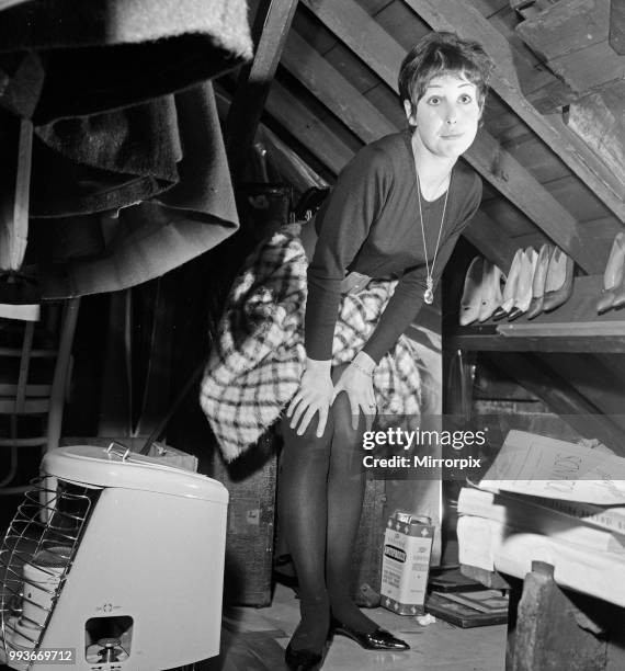 Dancer Una Stubbs, aged 22, in her flat in London. Inside the attic cupboard about to select a pair of shoes, 4th December 1959.