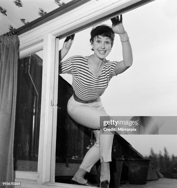 Dancer Una Stubbs, aged 22, in her flat in London. Outside Una's bedroom window is a flat bit of roof on which she sunbathes in summer, but now she...