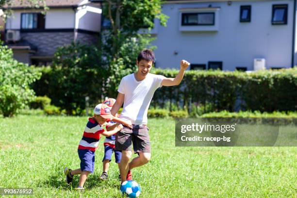 父が彼の子供たちとサッカーを楽しんで - サッカー 日本人 ストックフォトと画像