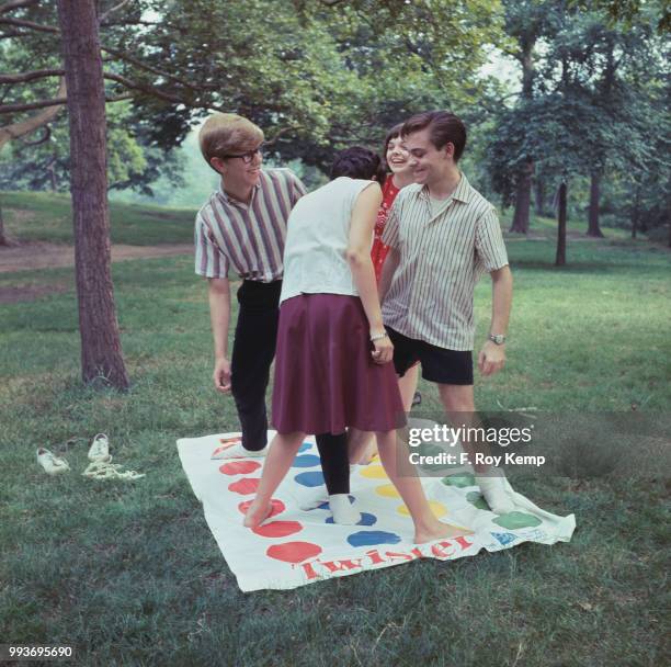 Four teenagers playing twister outdoors, 8th July 1966.